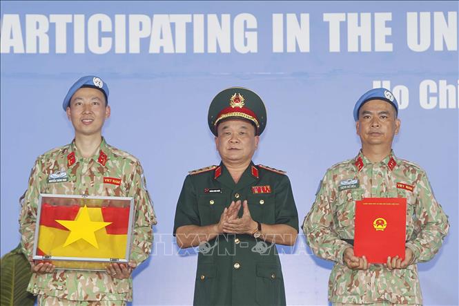 Trong ảnh: Thượng tướng Hoàng Xuân Chiến, Thứ trưởng Bộ Quốc phòng trao Quyết định của Chủ tịch nước và Quốc kỳ cho Bệnh viện dã chiến cấp 2 số 3 trước khi lên đường làm nhiệm vụ. Ảnh: Thanh Vũ-TTXVN