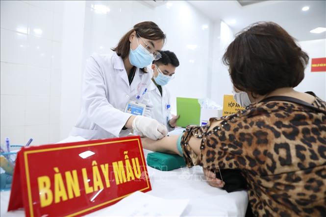 Photo: Take samples for testing on a volunteer before receiving the 2nd shot of Nano Covax vaccine in second trial phase. VNA Photo: Minh Quyết