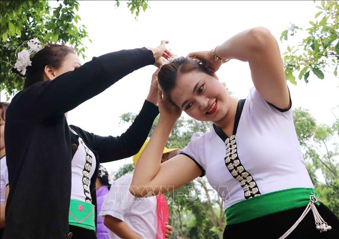 Phụ nữ Thái chỉnh sửa lại trang phục, kết tóc đi chơi hội Nàng Han. Ảnh: Nguyễn Oanh-TTXVN