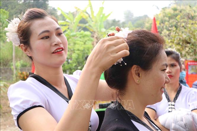 Phụ nữ Thái chỉnh sửa lại trang phục, kết tóc đi chơi hội Nàng Han. Ảnh: Nguyễn Oanh-TTXVN