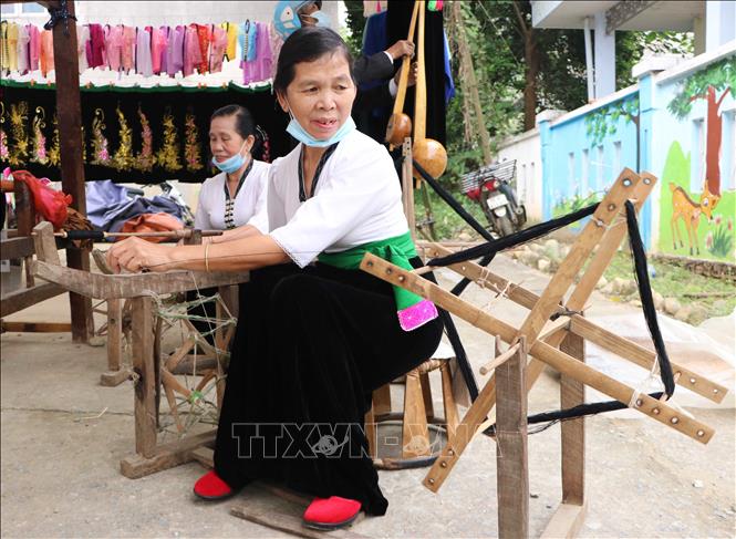 Phụ nữ Thái xã Mường So trổ tài quay sợi. Ảnh: Nguyễn Oanh-TTXVN