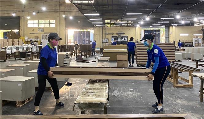 Công nhân Công ty Cổ phần Chế biến gỗ Thuận An kiểm tra các chi tiết khung giường gỗ. Ảnh: Hồng Nhung – TTXVN