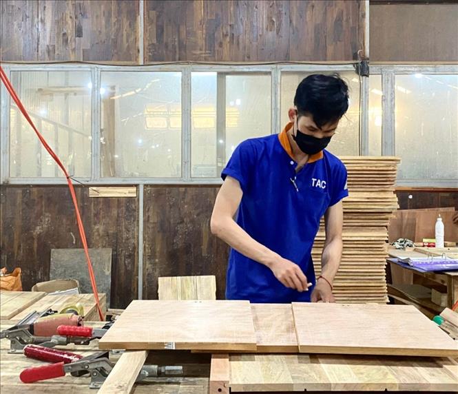 Công nhân Công ty Cổ phần Chế biến gỗ Thuận An làm các chi tiết mặt gỗ cổ điển theo đơn đặt hàng. Ảnh: Hồng Nhung – TTXVN