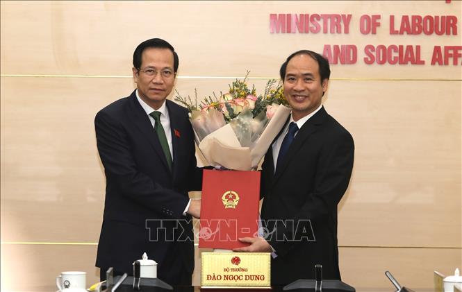 Trong ảnh: Bộ trưởng Bộ Lao động – Thương binh và Xã hội Đào Ngọc Dung trao quyết định và tặng hoa chúc mừng Thứ trưởng Nguyễn Văn Hồi. Ảnh: Hoàng Hiếu – TTXVN