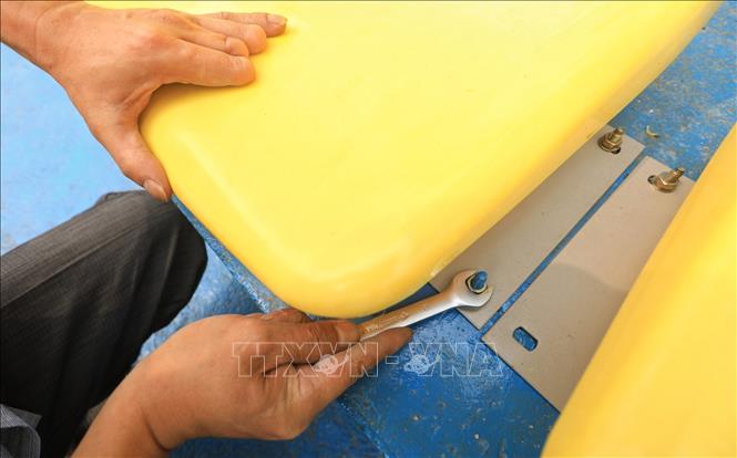 Trong ảnh: Đơn vị thi công lắp đặt, kiểm tra hệ thống ghế ngồi tại khán đài sân đá bóng Trung tâm VHTT và TT huyện Thanh Trì. Ảnh: Thành Đạt - TTXVN