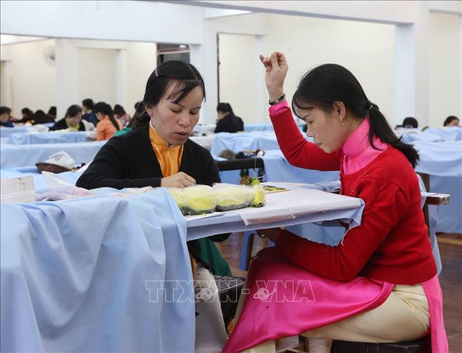 Các nghệ nhân thêu thực hiện tác phẩm tại XQ Đà Lạt Sử Quán, tỉnh Lâm Đồng. Ảnh: Phương Hoa - TTXVN