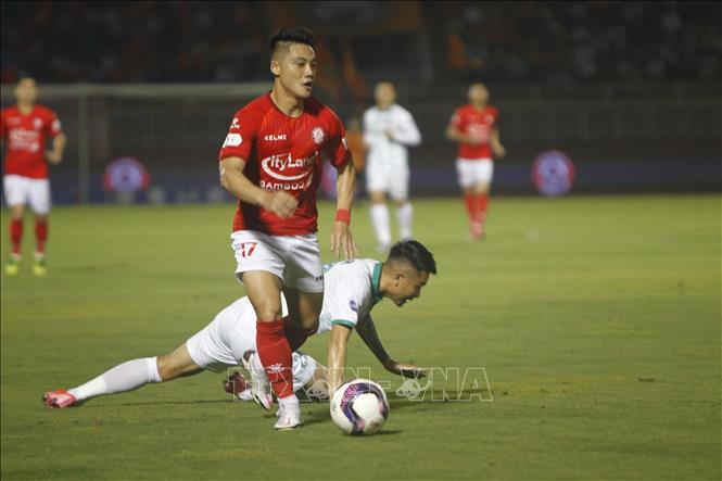 Trong ảnh: Pha đi bóng của cầu thủ TP. Hồ Chí Minh Lâm Ti Phông (17-áo đỏ) vượt qua các cầu thủ đội Bình Định (áo trắng). Ảnh: Thanh Vũ-TTXVN
