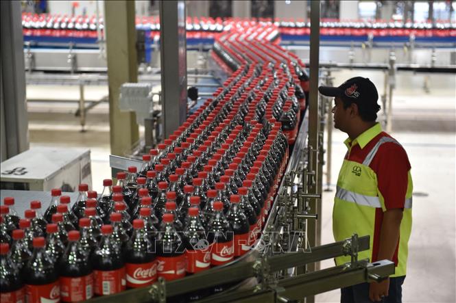 Trong ảnh: Công nhân làm việc tại một nhà máy của Coca Cola ở Cikedokan, Bekasi-West Java, Indonesia. Ảnh: AFP/ TTXVN