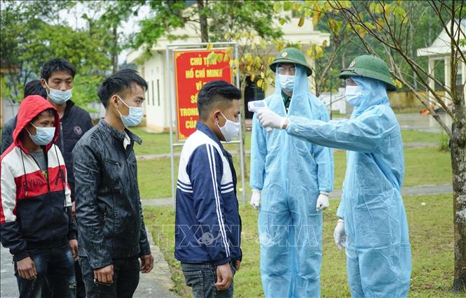 Trong ảnh: Lực lượng chức năng kiểm tra thân nhiệt các đối tượng người Việt Nam bị bắt. Ảnh: Xuân Tư – TTXVN