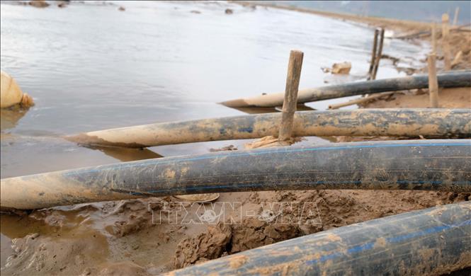 Trong ảnh: Các đường ống của máy bơm như những “vòi bạch tuộc” cố gắng hút những nguồn nước cuối cùng trong lòng hồ Đankia – Suối Vàng. Ảnh: Nguyễn Dũng – TTXVN 