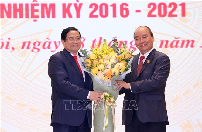 Trong ảnh: Chủ tịch nước Nguyễn Xuân Phúc, nguyên Thủ tướng Chính phủ tặng hoa chúc mừng Thủ tướng Chính phủ Phạm Minh Chính. Ảnh: TTXVN