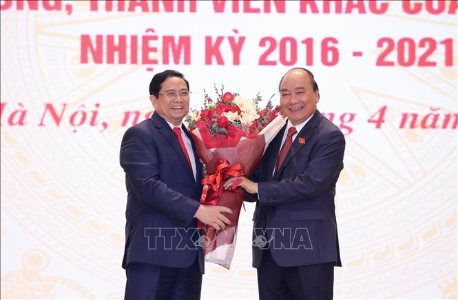 Trong ảnh: Thủ tướng Phạm Minh Chính tặng hoa chúc mừng Chủ tịch nước Nguyễn Xuân Phúc. Ảnh: Dương Giang - TTXVN