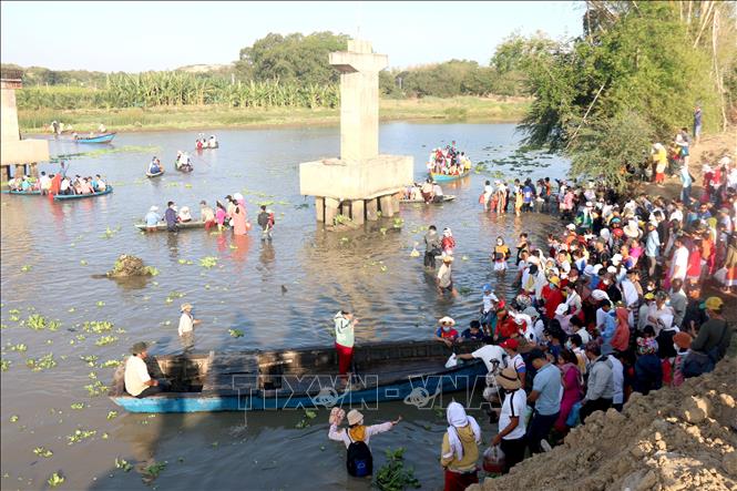 Trong ảnh: Người dân đi đò qua sông Lũy để đến khu nghĩa trang của người Chăm. Ảnh: Nguyễn Thanh - TTXVN