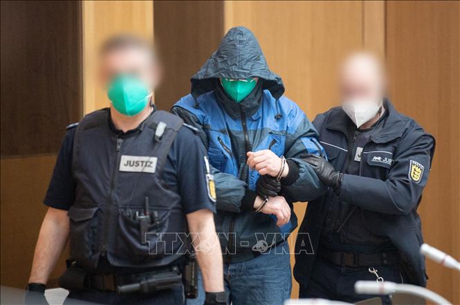 Trong ảnh: Cảnh sát Đức áp giải một đối tượng thành viên Nhóm S (Gruppe S), bị cáo buộc tham gia và ủng hộ tổ chức khủng bố, tới phiên xét xử của toà án ở Stuttgart ngày 13/4/2021. Ảnh: AFP/TTXVN
