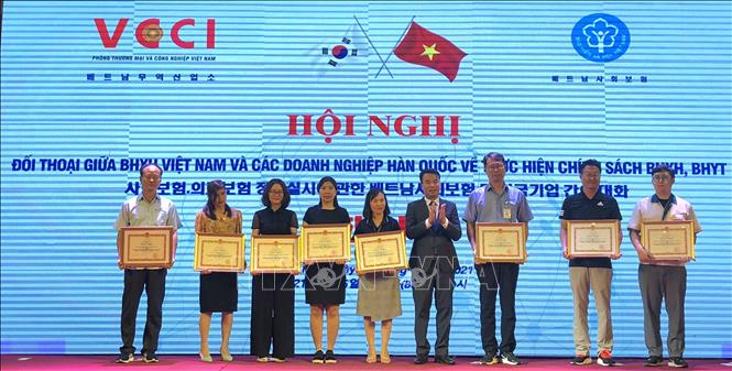 Trong ảnh: Ông Nguyễn Thế Mạnh, Tổng giám đốc Bảo hiểm xã hội Việt Nam tặng bằng khen cho các doanh nghiệp Hàn Quốc.Ảnh: Nguyễn Văn Việt - TTXVN