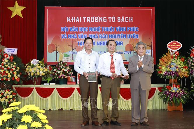 Trong ảnh:  Nhà văn, nhà báo Nguyễn Uyển tặng sách cho lãnh đạo UBND xã Nghĩa Hưng. Ảnh: Hoàng Hùng - TTXVN