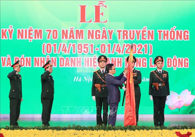 Trong ảnh: Phó Thủ tướng Vũ Đức Đam gắn Danh hiệu Anh hùng Lao động thời kỳ đổi mới lên lá cờ truyền thống của Bệnh viện Trung ương Quân đội 108. Ảnh: TTXVN