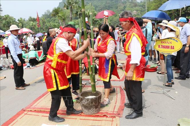Trong ảnh: Các đội tham gia phần thi giã bánh giầy. Ảnh: Trung Kiên – TTXVN.