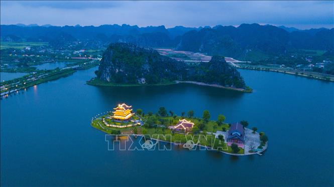 Một góc thành phố Ninh Bình khi lên đèn. Khi đêm về, cảnh núi non trùng điệp và những dấu ấn của không gian Phật giáo thanh tịnh, những hồ nước, sông ngòi lấp loáng ánh trăng, đem lại vẻ đẹp huyền bí cho thành phố. Ảnh: Minh Đức – TTXVN