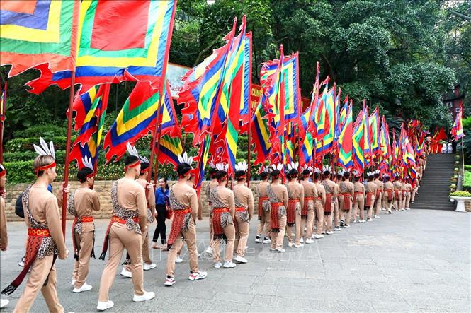 Trong ảnh: 100 thanh niên tượng trưng cho con Lạc, cháu Hồng trong trang phục cổ, tay giương cao cờ hội, thể hiện sức sống mãnh liệt của dòng giống Tiên Rồng. Ảnh: Trung Kiên – TTXVN