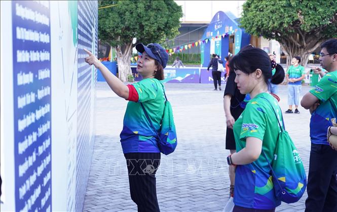 Các vận động viên xem danh sách niêm yết và sơ đồ cung đường chạy. Ảnh: Thanh Tân - TTXVN