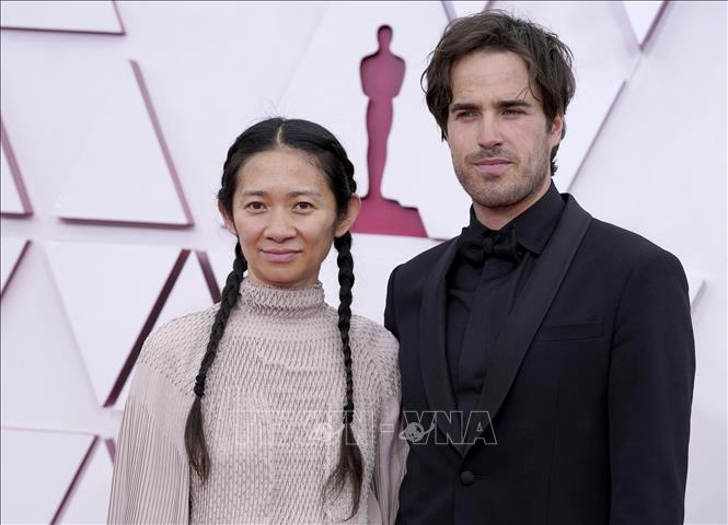 Trong ảnh: Nhà làm phim Chloe Zhao (trái) và nhà quay phim Joshua James Richards tới dự Lễ trao giải Oscars 2021 ở Los Angeles, Mỹ, ngày 25/4/2021. Ảnh: AFP/TTXVN