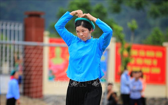 Trong ảnh: Cô gái Sán Chỉ chỉnh lại trang phục giữa trận đấu. Ảnh: Thành Đạt - TTXVN
