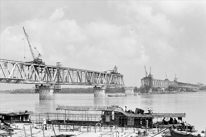 Cùng với lịch sử và sự phát triển của đất nước có những công trình mang đậm dấu ấn trí thức Việt trong lĩnh vực nghiên cứu ứng dụng, có những công trình là kết tinh trí tuệ, bản lĩnh và công sức của tập thể những người lao động Việt Nam để cống hiến âm thầm cho cộng đồng. Trong ảnh: Cán bộ, công nhân xí nghiệp cầu Thăng Long lắp khoang cuối cùng của cầu (1983). Ảnh: TTXVN