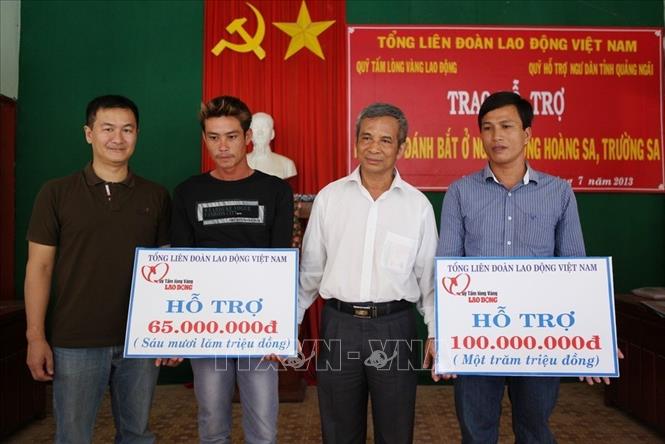 Trong ảnh: Chủ tịch Tổng Liên đoàn Lao động Việt Nam Đặng Ngọc Tùng trao tượng trưng tiền hỗ trợ ngư dân xã An Vĩnh, huyện Lý Sơ (Quảng Ngãi). Ảnh: Lâm Khánh – TTXVN.