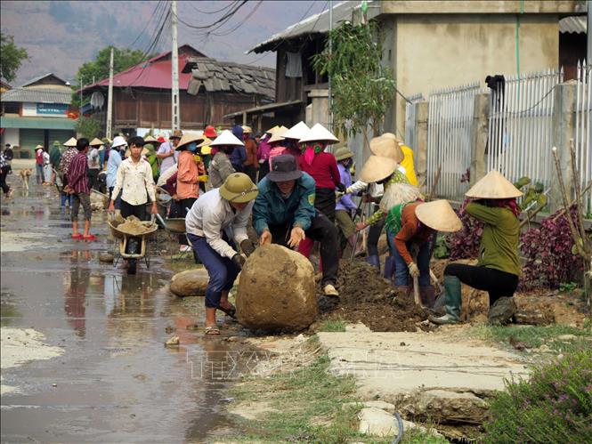 Trong ảnh: Người dân xã Ngọc Chiến tự nguyện đóng góp ngày công lao động để mở rộng đường giao thông nông thôn. Ảnh: Hữu Quyết - TTXVN 