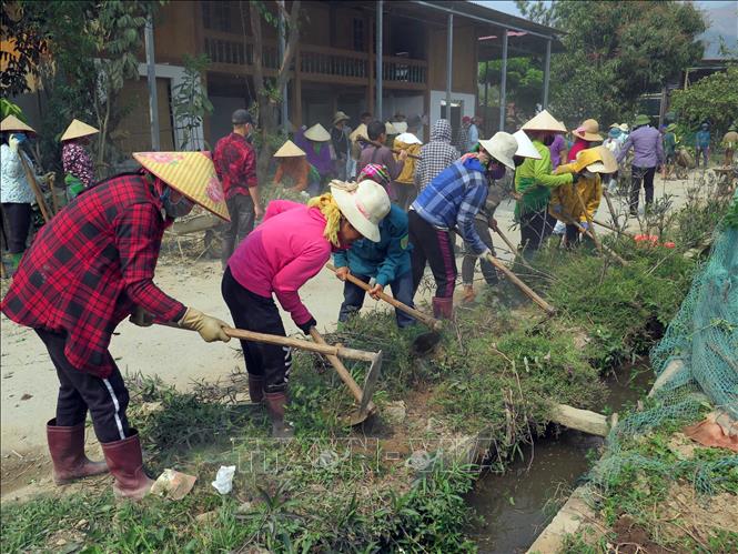 Trong ảnh: Người dân xã Ngọc Chiến khi tham gia đóng góp ngày công lao động để mở rộng đường giao thông nông thôn. Ảnh: Hữu Quyết - TTXVN 