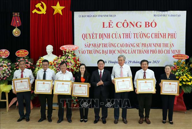 Trong ảnh: Chủ tịch UBND tỉnh Ninh Thuận Trần Quốc Nam tặng bằng khen cho các cá nhân có thành tích xuất sắc trong triển khai Đề án sáp nhập trường. Ảnh: Công Thử - TTXVN
