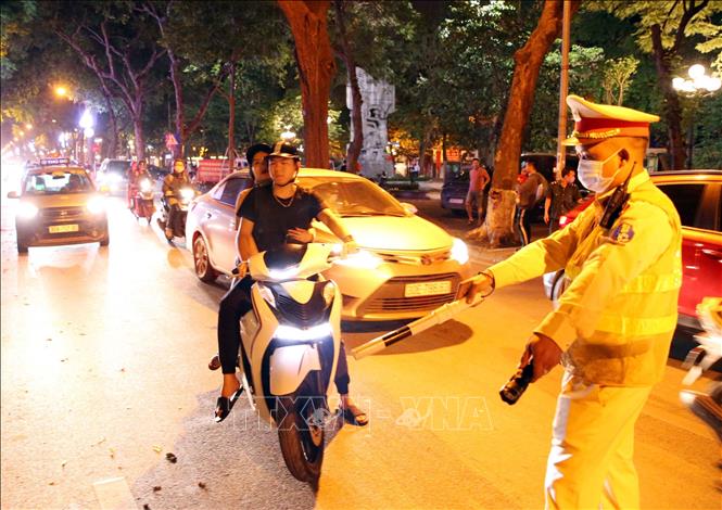 Trong ảnh: Tổ công tác đặc biệt Y20/141 kiểm tra hành chính với chủ phương tiên tham gia giao thông không đeo khẩu trang và có biểu hiện nghi vấn, đêm 29 rạng sáng 30/4. Ảnh: Phạm Kiên - TTXVN