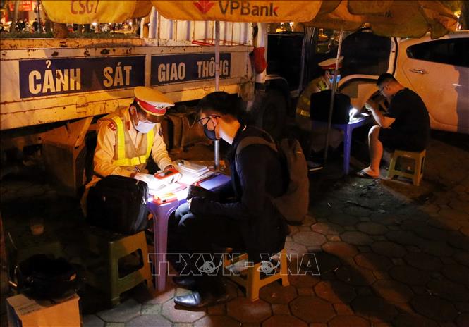 Trong ảnh: Lực lượng CSGT kiểm tra và lập biên bản xử lý chủ phương tiện vi phạm trật tự ATGT tại phố Phan Đình Phùng, đêm 29 đến rạng sáng 30/4. Ảnh: Phạm Kiên - TTXVN