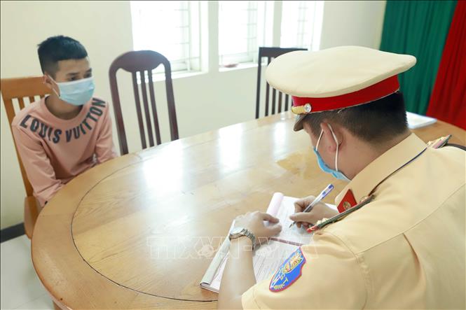 Trong ảnh: Cảnh sát giao thông Tam Đảo lập biên bản xử lý chủ phương tiện vi phạm. Ảnh: Hoàng Hùng - TTXVN