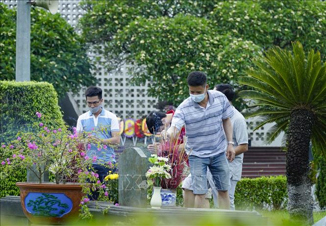Trong ảnh: Hầu hết du khách đều chấp hành nghiêm việc đeo khẩu trang khi đến thắp hương tại các Nghĩa trang Liệt sỹ. Ảnh: Xuân Tư – TTXVN