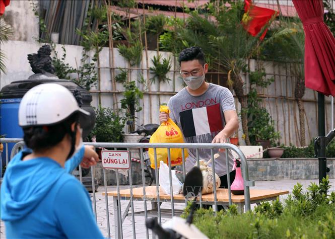 Trong ảnh: Người thân đưa đồ nhu yếu phẩm thiết yếu tiếp tế cho cư dân sống tại Toà chung cư Viễn Đông Star (số 1 phố Giáp Nhị, quận Hoàng Mai, Hà Nội) bị phong tỏa. Ảnh: Phạm Kiên - TTXVN
