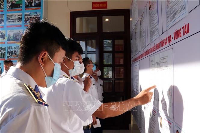 Trong ảnh: Cán bộ, chiến sĩ tìm hiểu thông tin ứng cử viên tại Trụ sở Cảnh sát biển Vùng 3. Ảnh:  Đoàn Mạnh Dương-TTXVN 