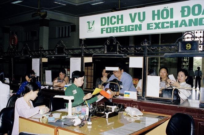 Trong ảnh: Hoạt động thu đổi ngoại tệ tại ngân hàng Vietcombak chi nhánh thành phố Hồ Chí Minh (1999). Ảnh: Quang Hải – TTXVN