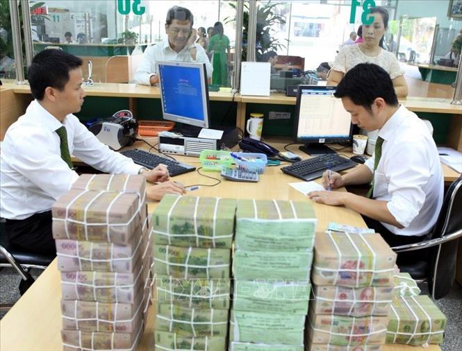 Trong ảnh: Chuẩn bị tiền mặt cho khách hàng vay vốn tại Vietcombank chi nhánh Hà Nội (2014). Ảnh: Trần Việt – TTXVN