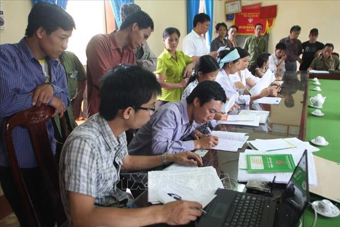 Trong ảnh: Nhân viên ngân hàng CSXH huyện Võ Nhai (Thái Nguyên) làm thủ tục cho hộ nghèo vay vốn tại điểm giao dịch xã Sảng Mộc (2013). Ảnh: Trần Việt – TTXVN