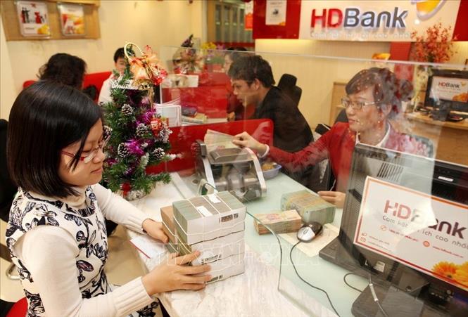 Trong ảnh: Khách hàng giao dịch tại phòng giao dịch HD Bank Trần Hưng Đạo, chi nhánh Hà Nội. Ảnh: Trần Việt- TTXVN