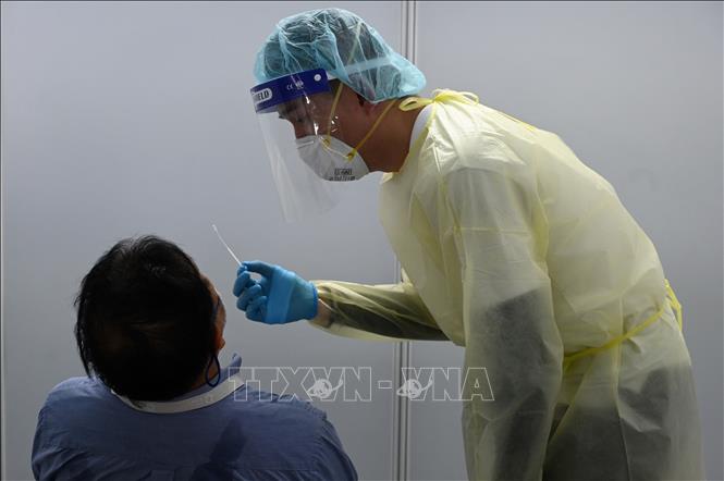 Trong ảnh: Nhân viên y tế lấy mẫu xét nghiệm COVID-19 cho du khách tại Vịnh Marina, Singapore ngày 6/11/2020. Ảnh: AFP/TTXVN