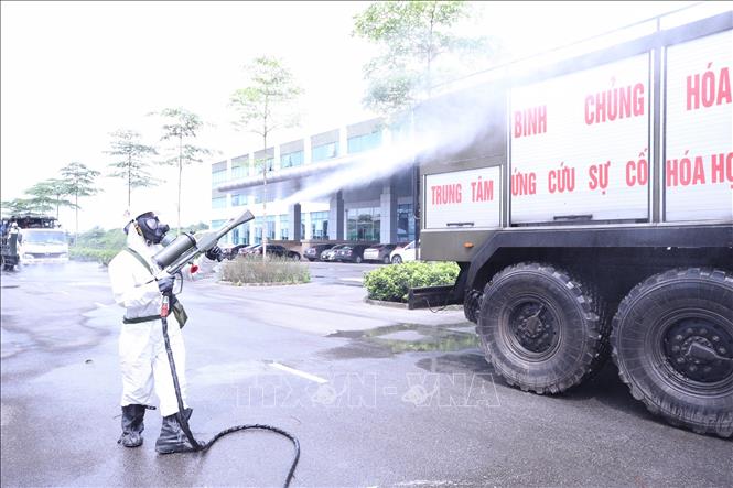 Bộ đội hóa học phun thuốc khử trùng tất cả phương tiện ra vào Bệnh viện Bệnh Nhiệt đới Trung ương cơ sở Đông Anh. Ảnh: Minh Đức-TTXVN 