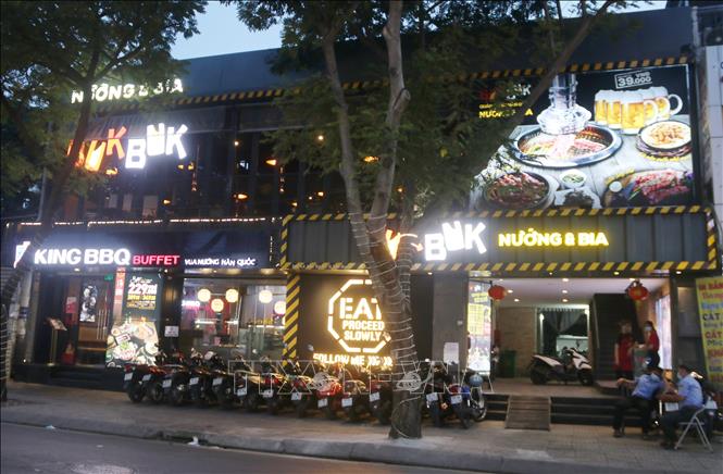 Trong ảnh: Các nhà hàng Buffet trên đường Lê Văn Sỹ (Quận 3) dù sáng đèn nhưng không nhận phục vụ khách từ 18h ngày 7/5. Ảnh: Thu Hương - TTXVN