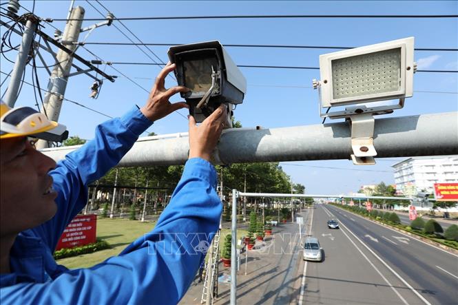 Trong ảnh: Nhân viên VNPT lắp đặt, bảo dượng hệ thống camera giao thông được kết nối với Trung tâm Điều hành và Giám sát thông minh (IOC) tỉnh Bình Phước. Ảnh: Minh Quyết - TTXVN 