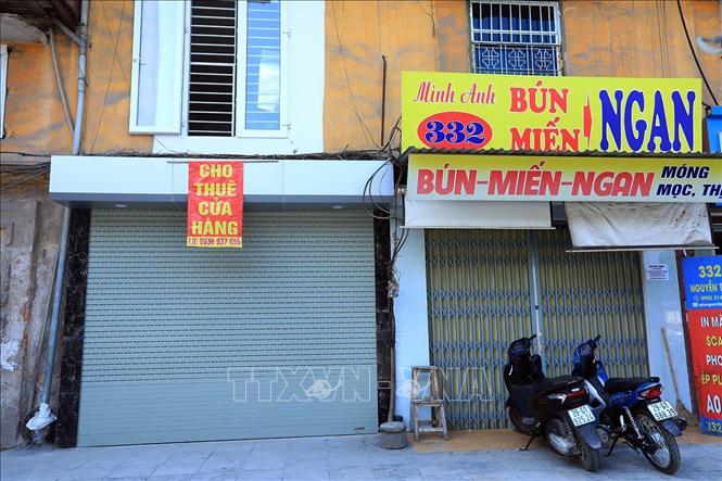 Trong ảnh: Một cửa hàng ăn phải đóng cửa và một cửa hàng tìm khách đến thuê trên đường Nguyễn Trãi, quận Thanh Xuân. Ảnh: Phan Tuấn Anh - TTXVN