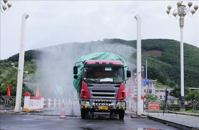 Trong ảnh: Các phương tiện vận chuyển hàng hóa xuất, nhập khẩu được hệ thống phun trùng khử khuẩn phòng chống dịch tại cầu Hữu nghị Việt Trung (Cửa khẩu Ma Lù Thàng). Ảnh: Quý Trung – TTXVN