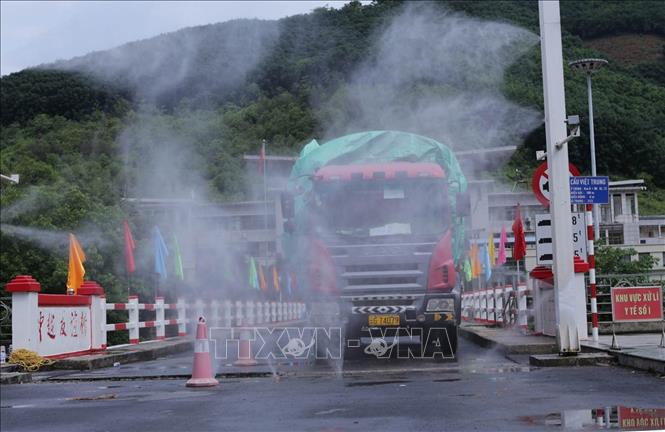 Trong ảnh: Các phương tiện vận chuyển hàng hóa xuất, nhập khẩu được hệ thống phun trùng khử khuẩn phòng chống dịch tại cầu Hữu nghị Việt Trung (Cửa khẩu Ma Lù Thàng). Ảnh: Quý Trung - TTXVN