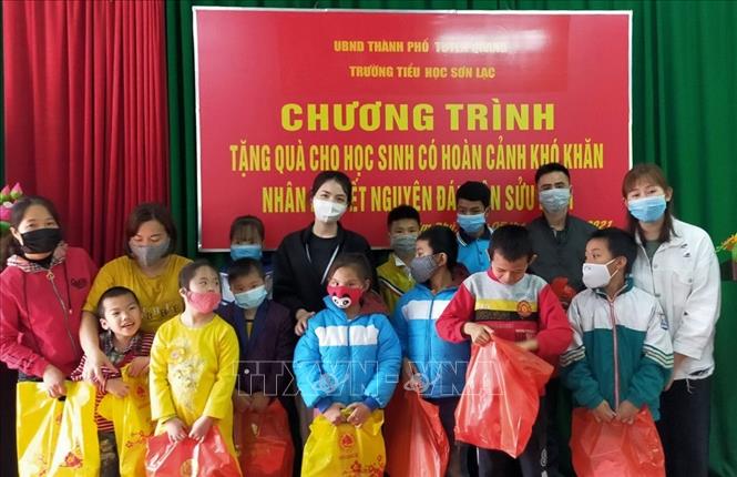 Trong ảnh: Em Đỗ Trần Diễm Mai và các bạn trong CLB Cây xanh trao quà cho các em học sinh nghèo tại trường Tiểu học Sơn Lạc (thành phố Tuyên Quang). Ảnh: TTXVN phát